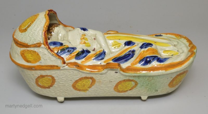 Large prattware pottery sleeping child in a cradle, circa 1820