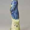 Pearlware pottery figure of a man playing the hardy curdy decorated with colours under the glaze, circa 1800