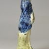 Pearlware pottery figure of a man playing the hardy curdy decorated with colours under the glaze, circa 1800