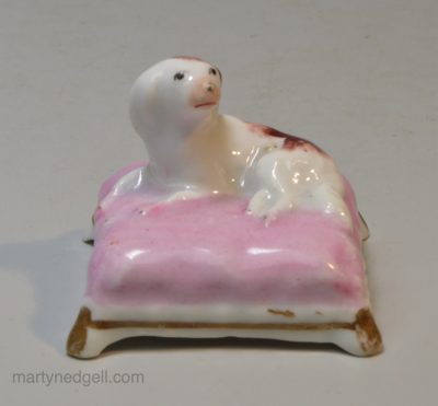 Staffordshire porcelain spaniel on a cushion, circa 1830