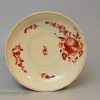 Creamware pottery coffee cup and saucer painted with red enamels over the glaze, circa 1770, probably Leeds Pottery