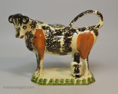 Creamware pottery cow creamer decorated with colours under the glaze, circa 1820