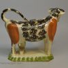 Creamware pottery cow creamer decorated with colours under the glaze, circa 1820
