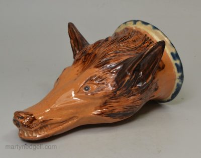 Buff pottery fox head stirrup cup, circa 1820