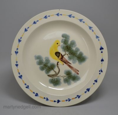 Creamware pottery plate decorated with a canary and sponged trees under the glaze, circa 1820