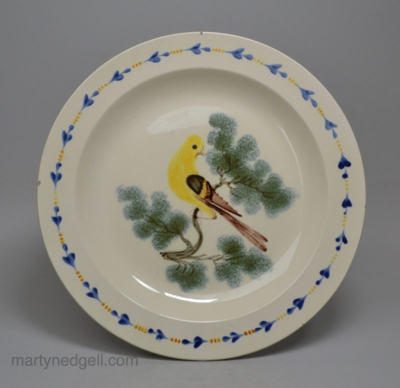 Creamware pottery plate decorated with a canary and sponged trees under the glaze, circa 1820