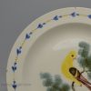 Creamware pottery plate decorated with a canary and sponged trees under the glaze, circa 1820