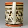 Mochaware mug decorated with inlaid brown slip on a creamware pottery body, circa 1820