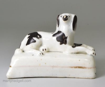 Staffordshire porcelain spaniel on a cushion, circa 1840