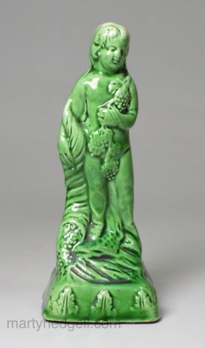 Creamware gren glazed pottery figure of a bacchanalian boy, circa 1790