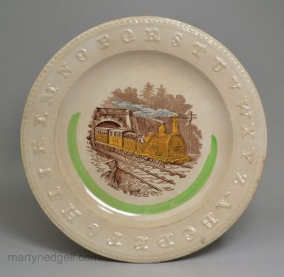 Pearlware pottery child's alphabet plate decorated with a print of a steam train, circa 1880