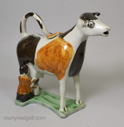 Pearlware pottery cow creamer decorated with colours under the glaze, circa 1820