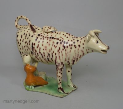 Creamware pottery cow creamer decorated with colours under the glaze, circa 1810