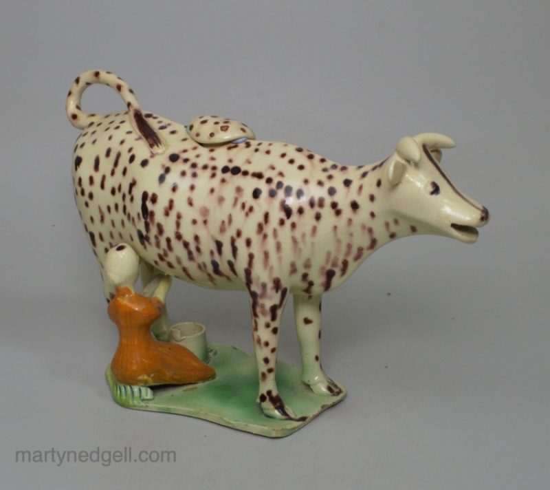 Creamware pottery cow creamer decorated with colours under the glaze, circa 1810