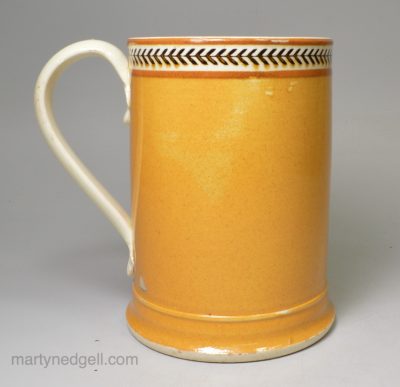 Creamware pottery mug decorated with pumpkin slip and brown inlayed, circa 1810