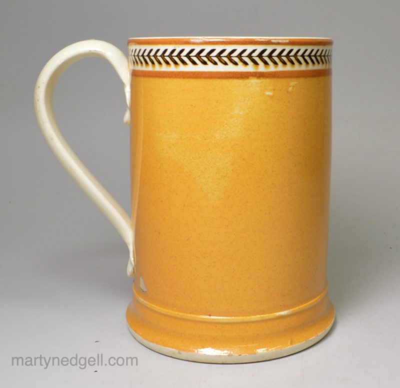 Creamware pottery mug decorated with pumpkin slip and brown inlayed, circa 1810