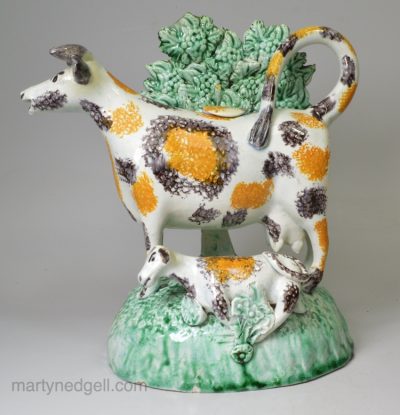 Pearlware pottery cow and calf bocage creamer decorated under the glaze, circa 1800