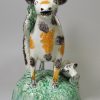 Pearlware pottery cow and calf bocage creamer decorated under the glaze, circa 1800