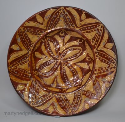 Early Staffordshire slipware dish decorated with a geometric design, circa 1670 - 1700