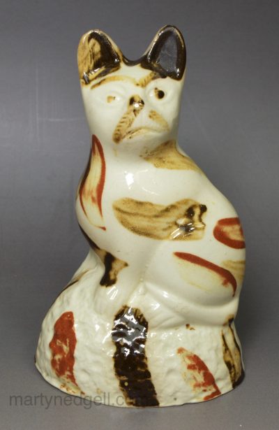 Creamware pottery cat decorated with splashes of slip, circa 1790, probably Bovey Tracey Pottery