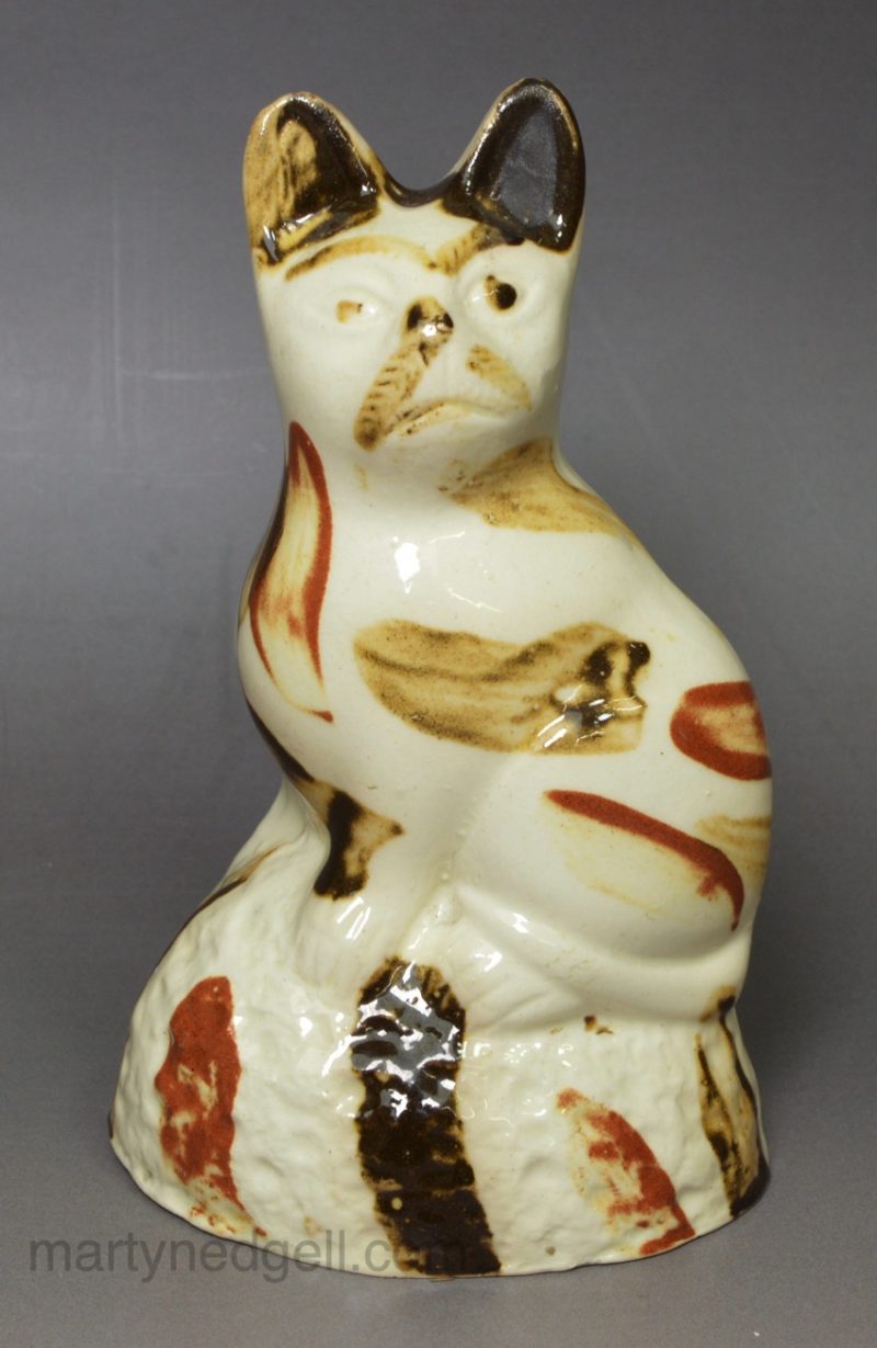 Creamware pottery cat decorated with splashes of slip, circa 1790, probably Bovey Tracey Pottery