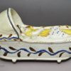 Pearlware pottery toy cradle and baby, circa 1820