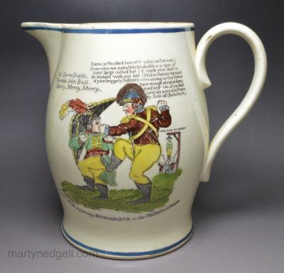 Creamware pottery jug decorated with a Napoleonic cartoon, circa 1815 JOHN BULL peppering BUONAPARTE in the FRONT and REAR