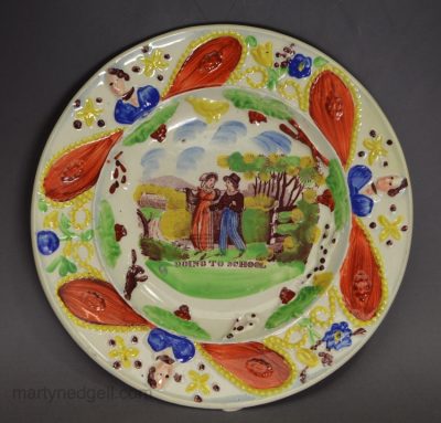Pearlware pottery child's plate decorated with a print 'GOING TO SCHOOL' and overglaze enamels, circa 1820