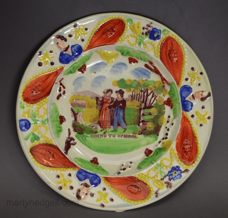 Pearlware pottery child's plate decorated with a print 'GOING TO SCHOOL' and overglaze enamels, circa 1820
