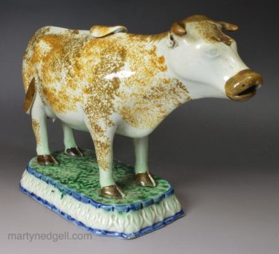 Pearlware pottery cow creamer decorated with colours under the glaze, circa 1820