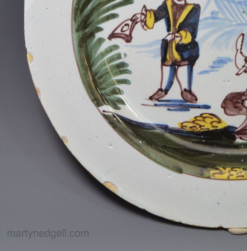 Liverpool delft plate painted with a couple in a rural setting, circa 1750