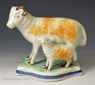 Pearlware pottery model of a sheep and it's lamb decorated under the glaze, circa 1810