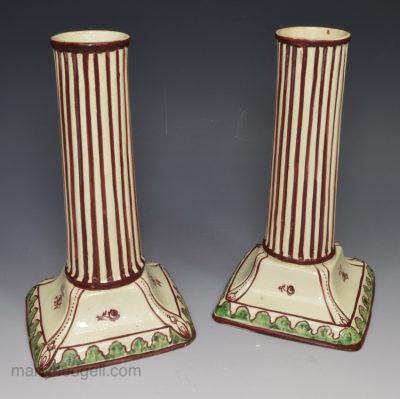 Pair of creamware pottery candlesticks decorated with enamels over the glaze, circa 1790