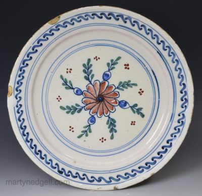 London delft pancake plate decorated with red, green and blue, circa 1740