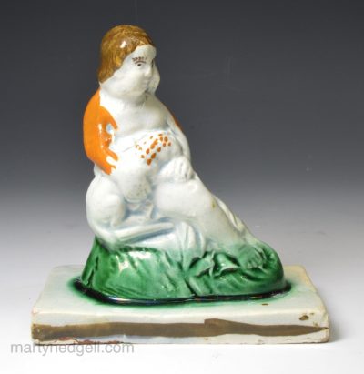 Pearlware pottery figure of a boy holding a dog, circa 1820