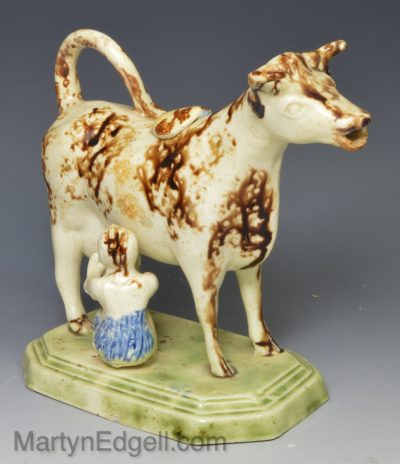 Creamware pottery cow creamer decorated with colours under the glaze, circa 1800