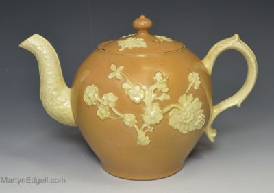 Stained buff creamware pottery teapot decorated with applied floral motifs, circa 1765