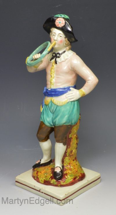 Staffordshire pearlware pottery figure of a boy playing a horn, circa 1820