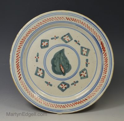 London delft pancake plate decorated with red, blue and green, circa 1730