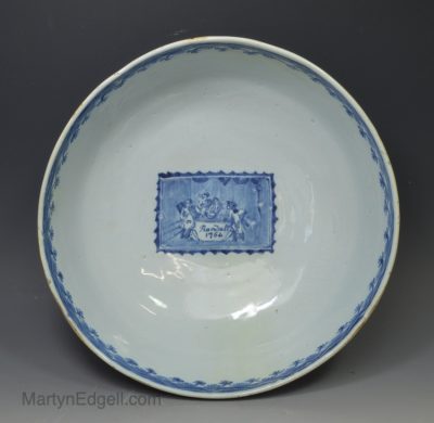 London delft punch bowl decorated with a Chinese landscape on the outside and a panel depicting four figures at a table, dated 1764