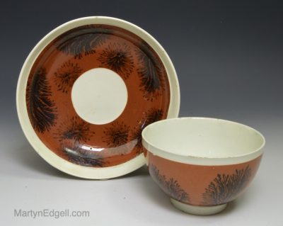 Pearlware pottery cup and saucer decorated with slip and dendritic mochaware markings, circa 1810