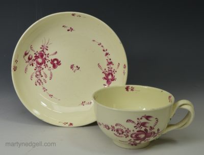 Creamware pottery cup and saucer decorated with enamels over the glaze, circa 1780