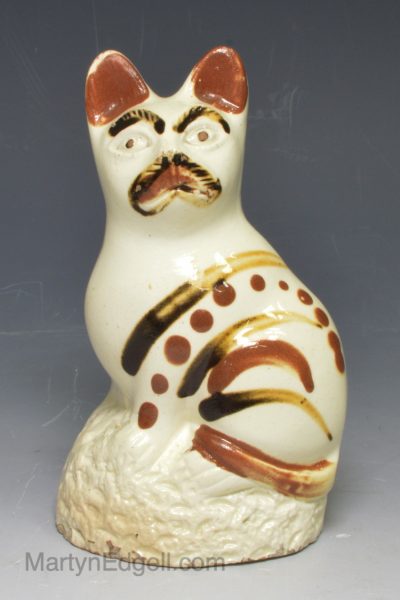 Creamware model of a cat decorated with painted slip, circa 1800, Bovey Tracey Pottery