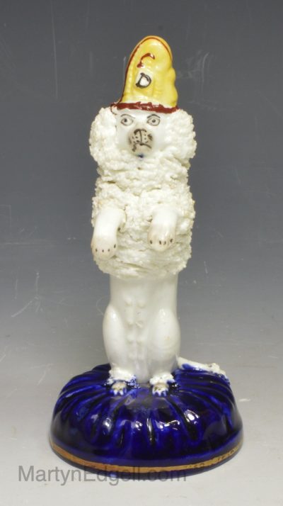 Staffordshire porcelain figure of a begging poodle with a dunce hat, circa 1840, possibly Alcock