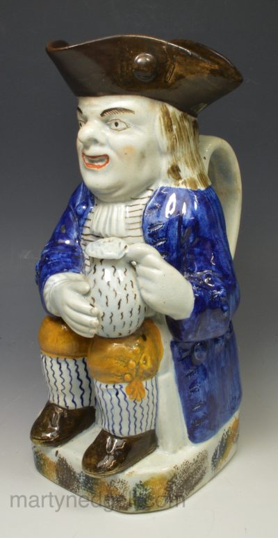 Prattware pottery Toby jug with hat decorated with colours under the glaze, circa 1820