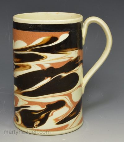 Creamware pottery mug decorated with tortoise shell slip, circa 1820