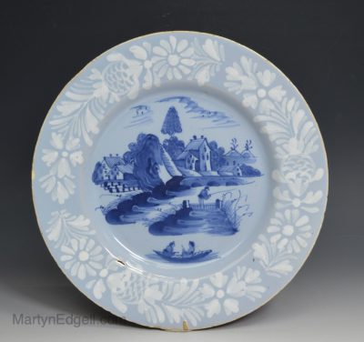 Bristol delft plate painted with a man fishing and a couple on a boat, circa 1750