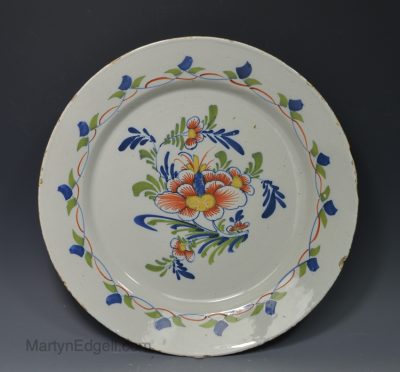 London delft polychrome charger decorated with a floral design, circa 1750