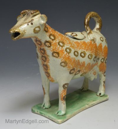 Pearlware pottery cow creamer decorated with sponging effect, circa 1820