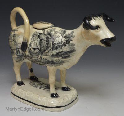 Swansea pearlware pottery cow creamer decorated with prints of rural scenes, circa 1830